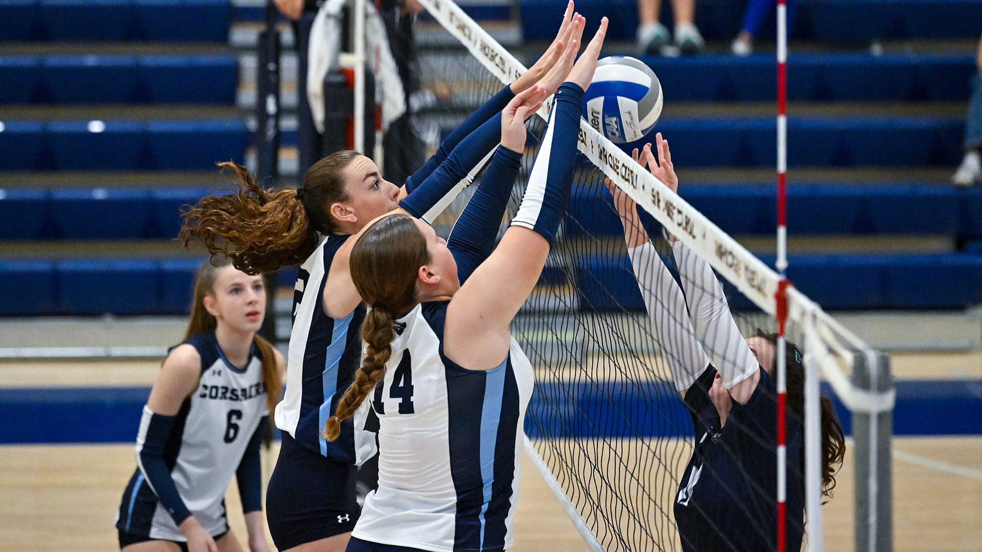 Maddie Carter and Olivia Seutter lay down a block in a match at Smith College
