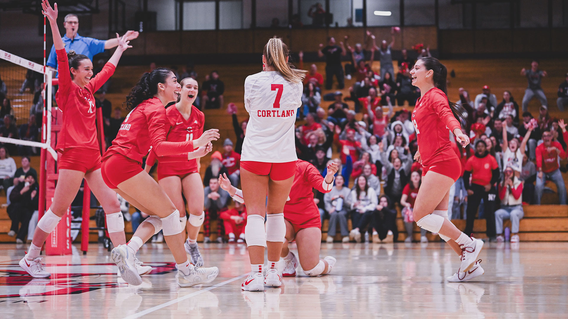 Cortland volleyball players celebrating after winning 2025 SUNYAC championship