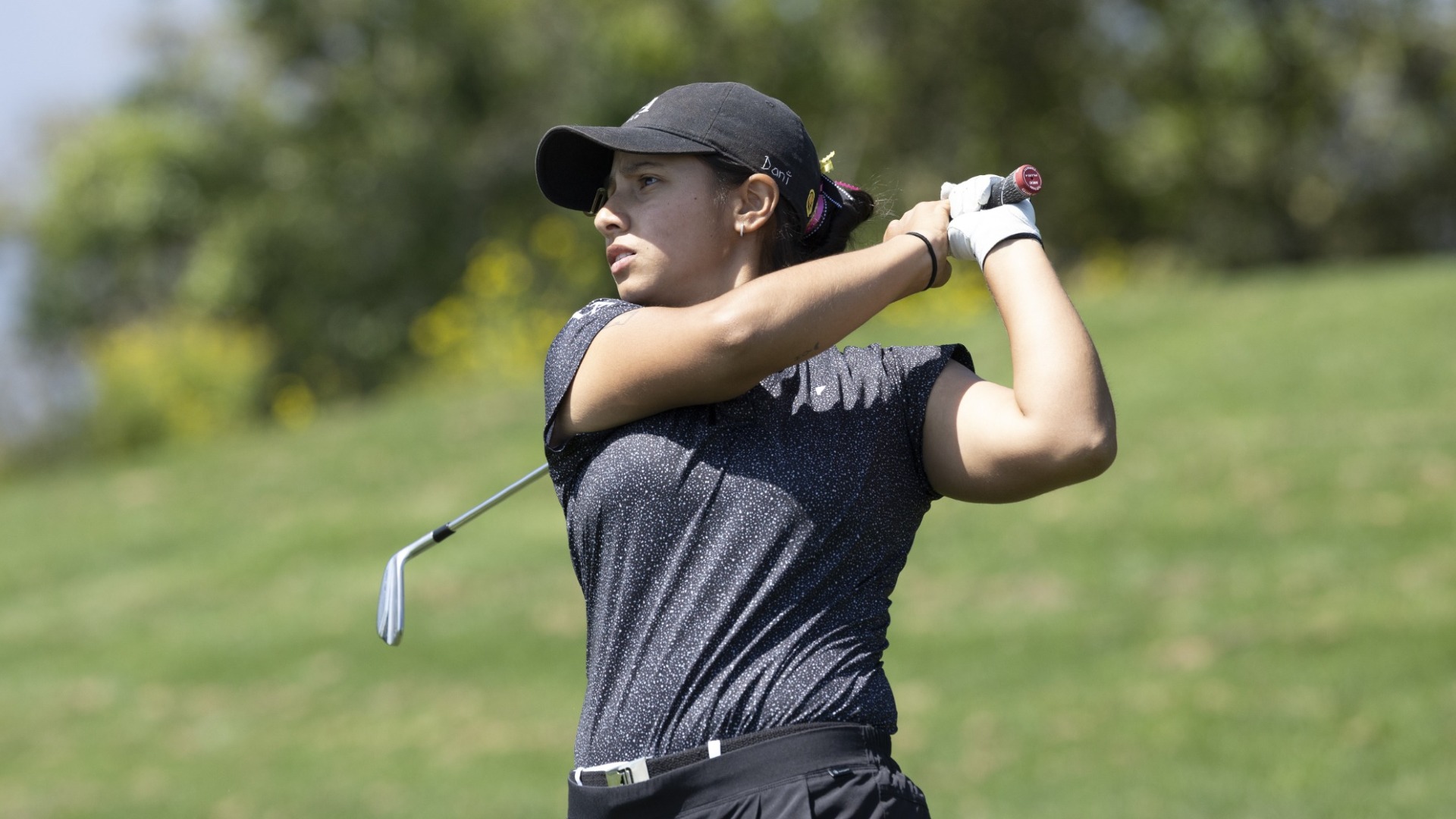 daniela andrade follows through on a golf shot