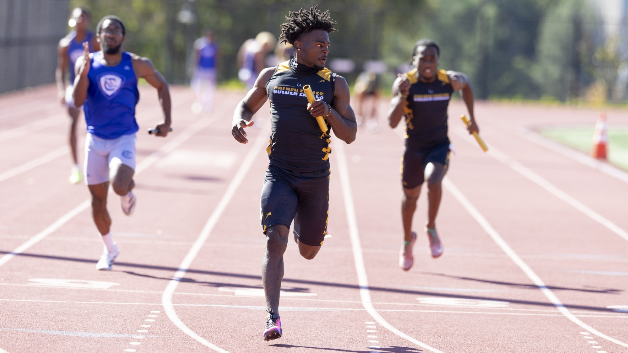 akeem murph crosses the finish line in the 4x100 relay