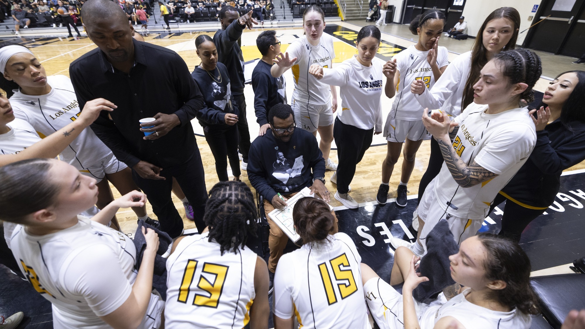 head coach torino johnson talks to the team during a timeout