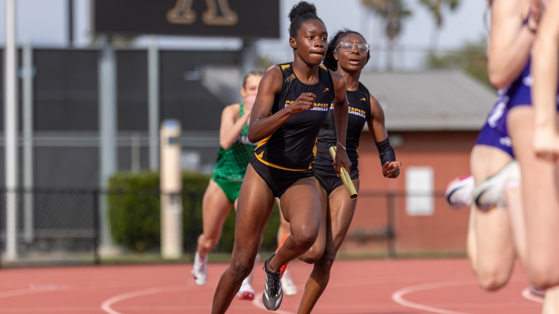 emmerson wiggins takes the handoff from ski'lar wallace in relay race