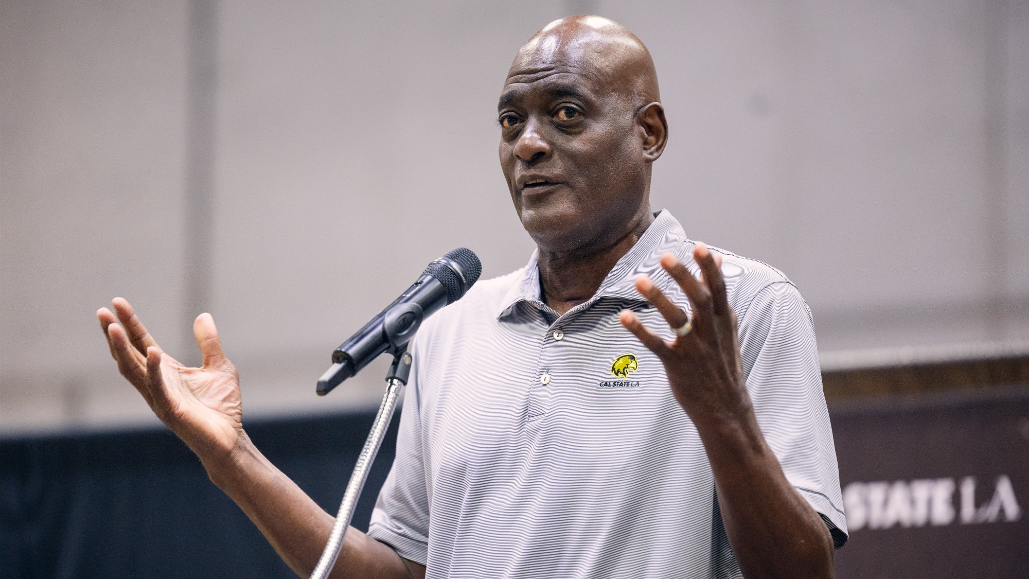new head coach michael cooper speaks at a press conference in university gym