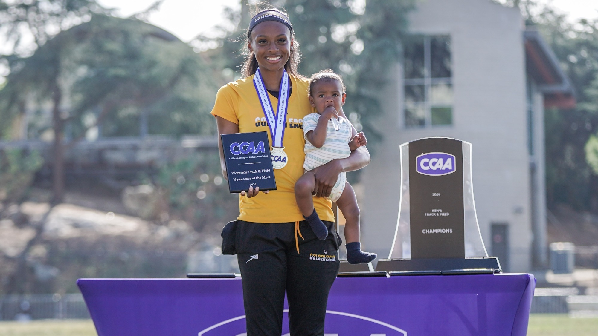 summer stevenson poses with newcomer of the meet award and son Dash