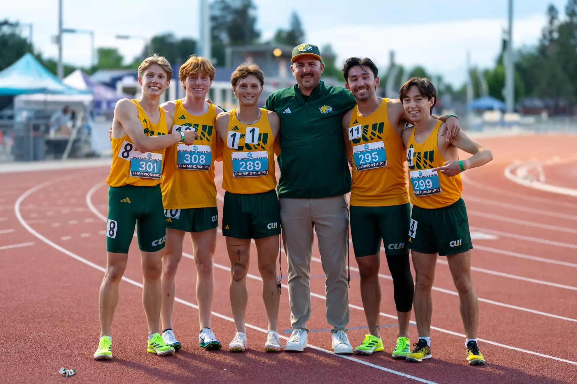 CUI Head Coach Keegan Bloomfield with distance runners 2025