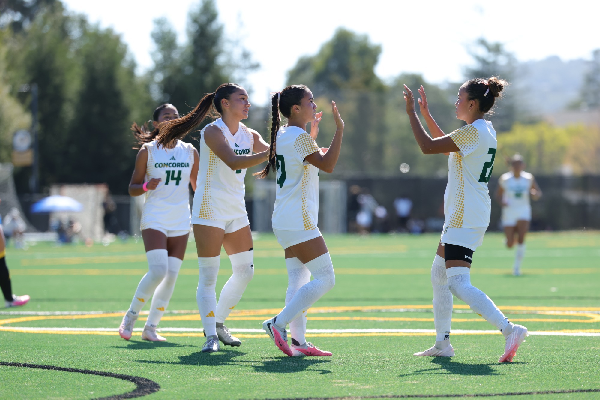 Ashley Grubert high fiving Mikayla Gonzalez after PK goal at Dominican