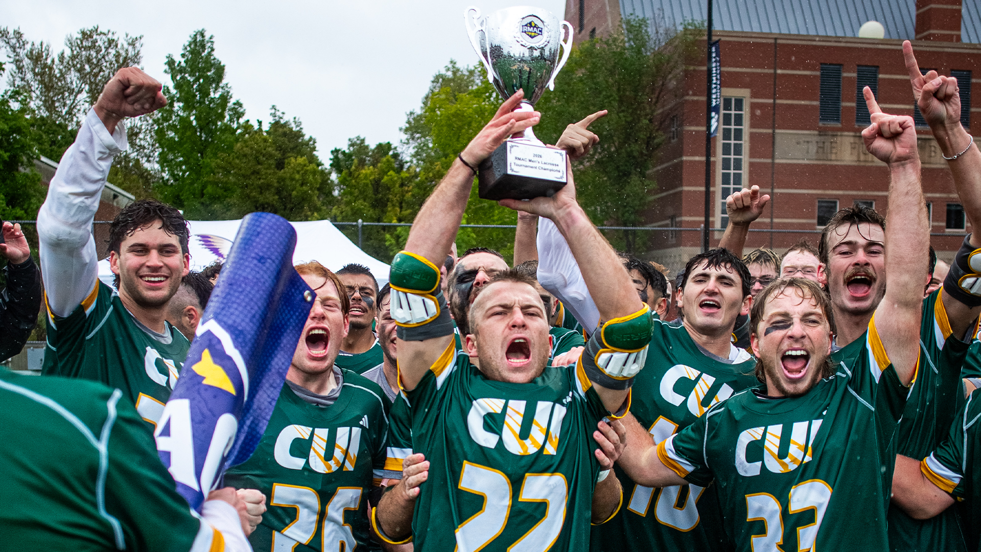 MLAX Cade Poe and team holding RMAC Trophy as 2026 Conference Champs