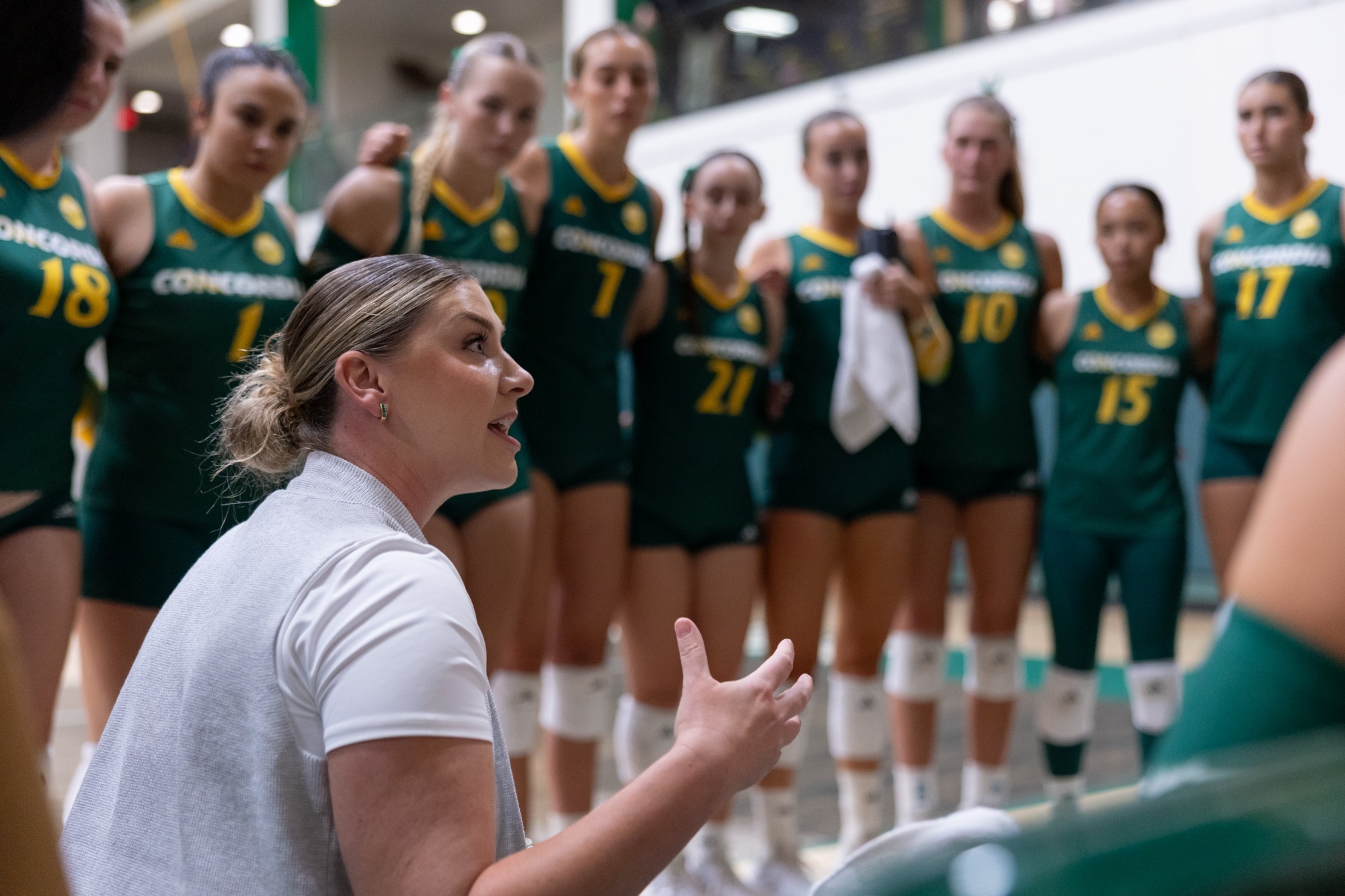 Coach Eryn Leja-Martin in volleyball huddle during 2026 match