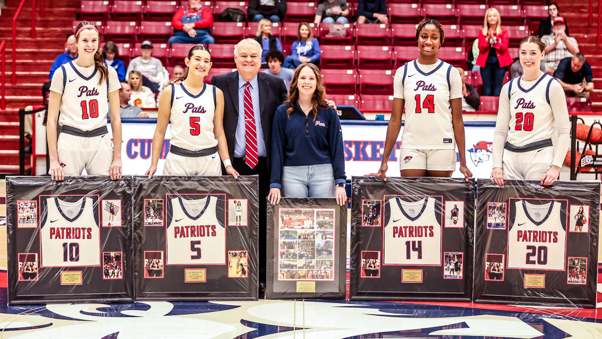 Women's Basketball Seniors with Coach Reeves and their framed jerseys