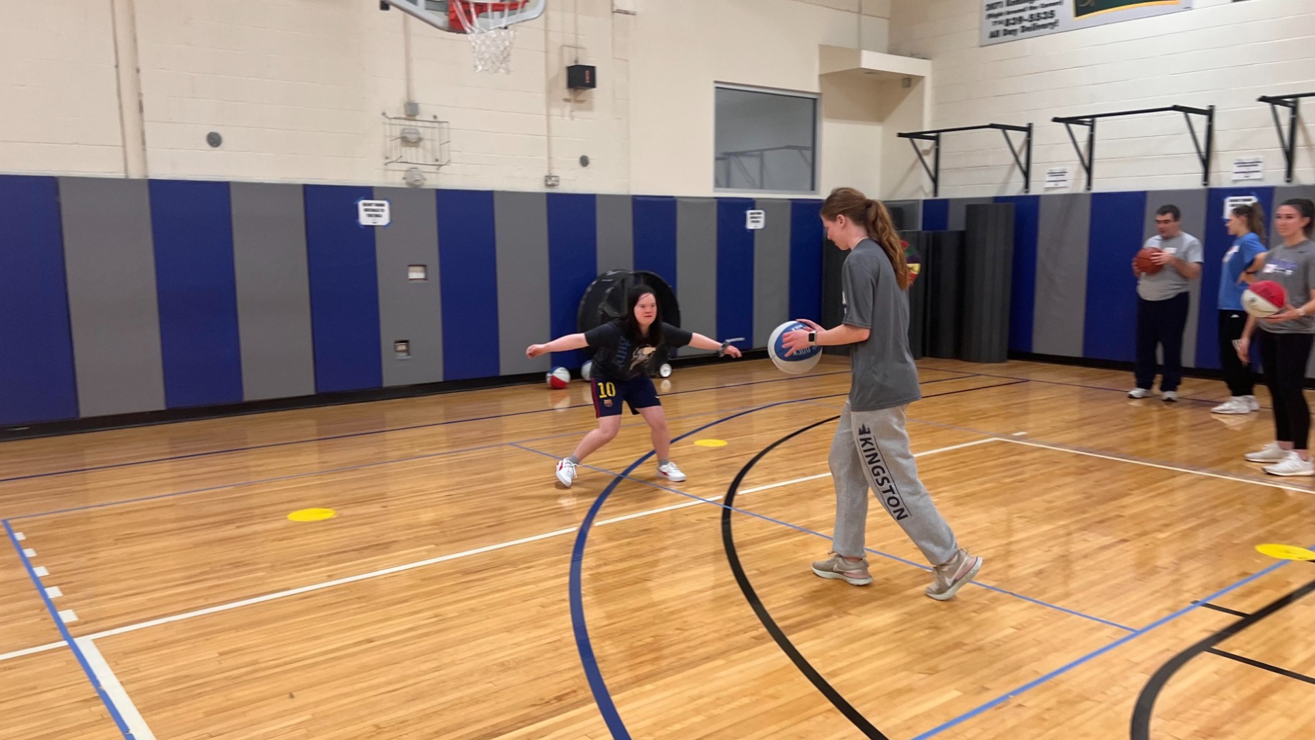 A CAUSE teammate plays defense on another teammate in basketball