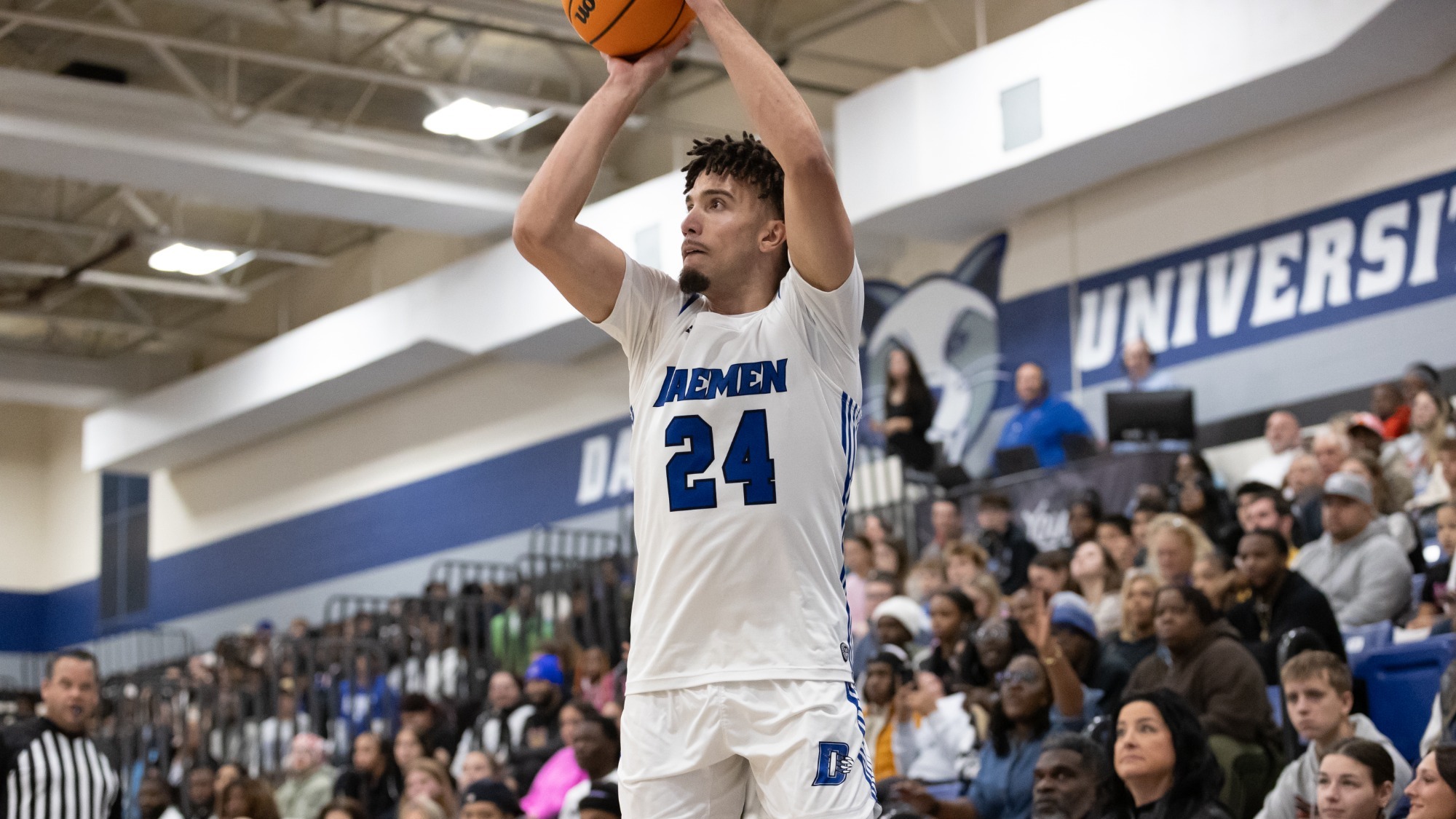 Ronnie Williams shoots a three-pointer in front of a packed Lumsden Gymnasium crowd