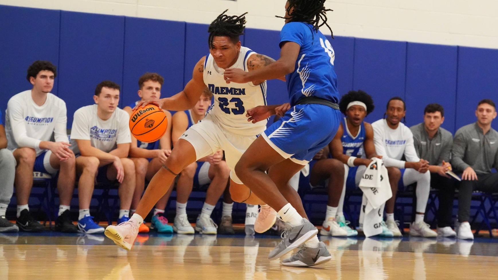 Justin Hemphill dribbles into an Assumption defender along the baseline.