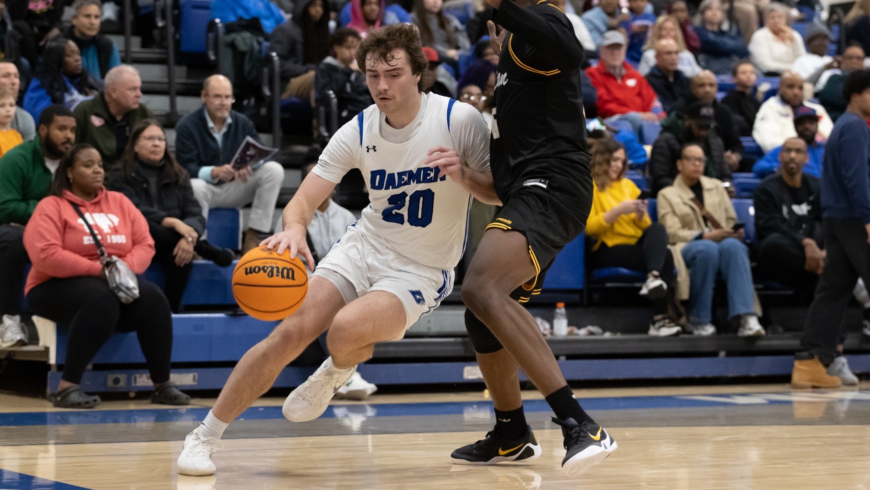 Zach Philipkoski leans into a defender while dribbling along the baseline