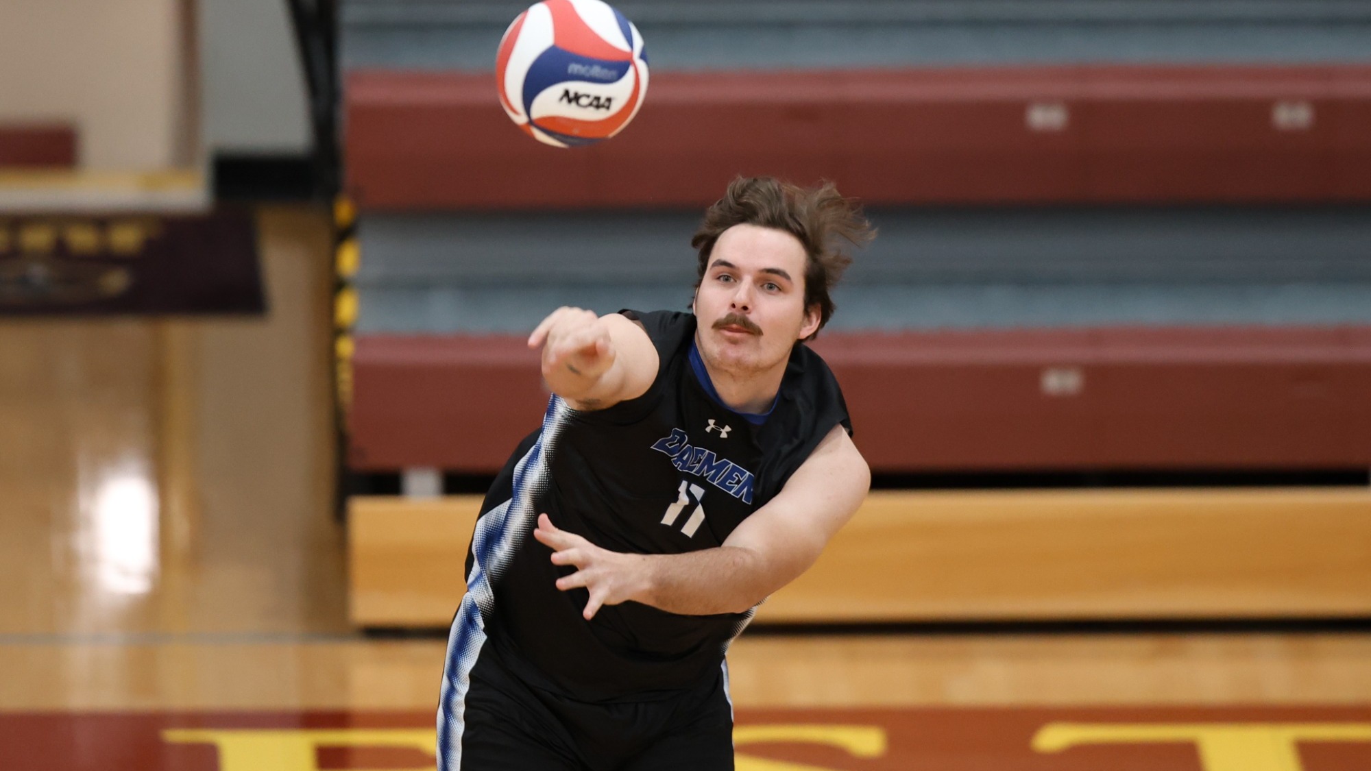 Jake Basinski serves the volleyball