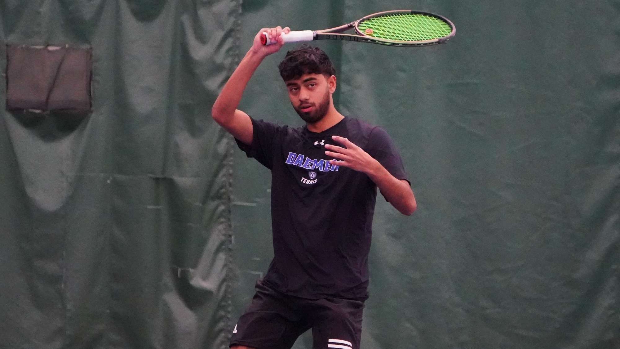 Rohan Chitanand follow through on tennis swing