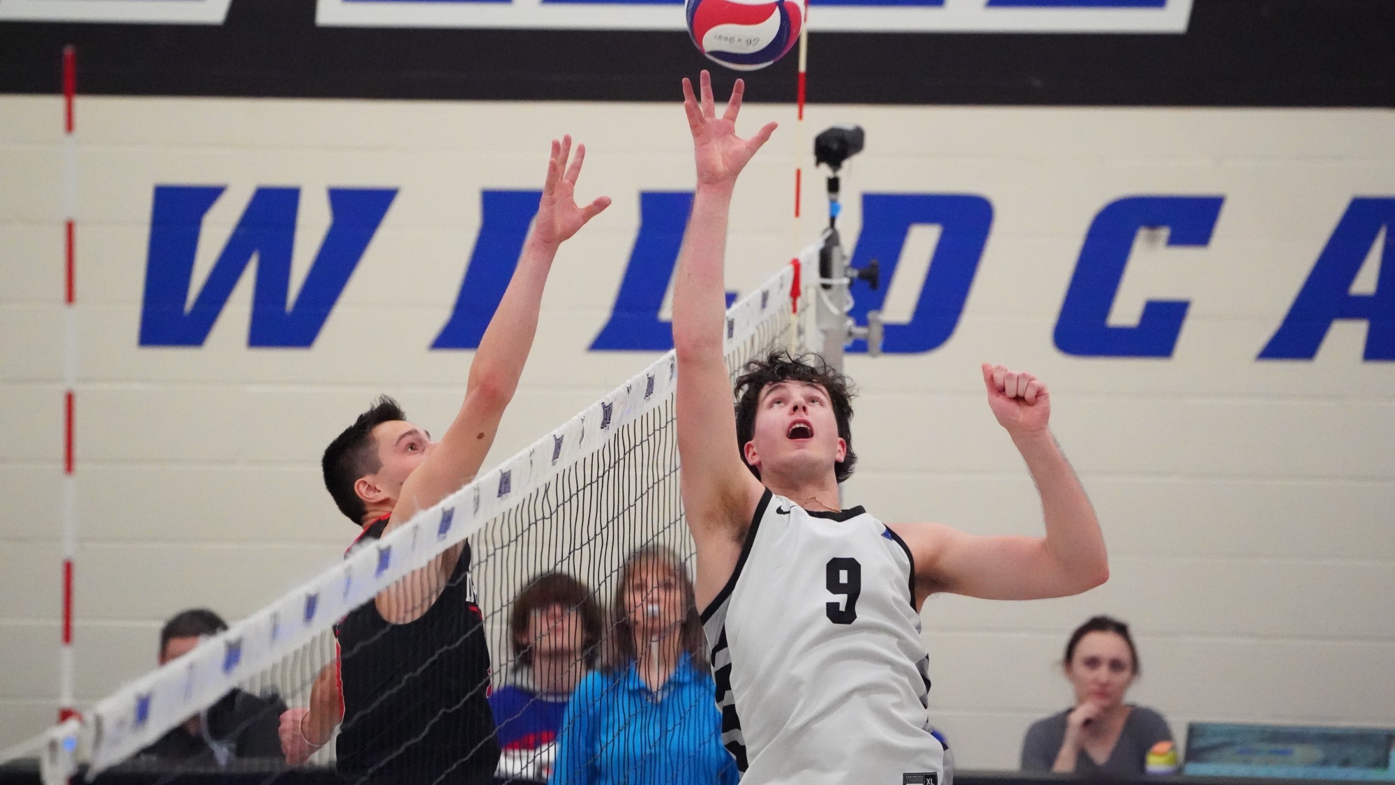 Bradyn Winters tips the volleyball at the net