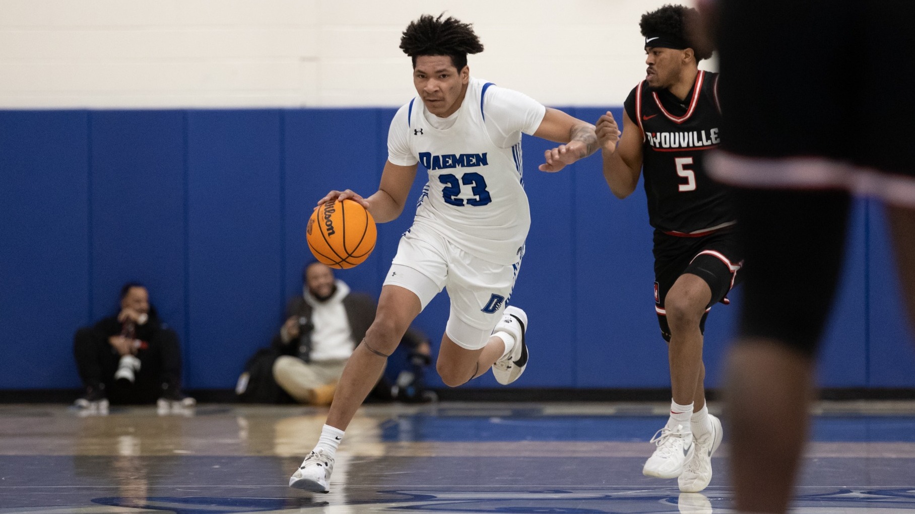 Justin Hemphill dribbles up the court as a D'Youville defender pressures on his left side