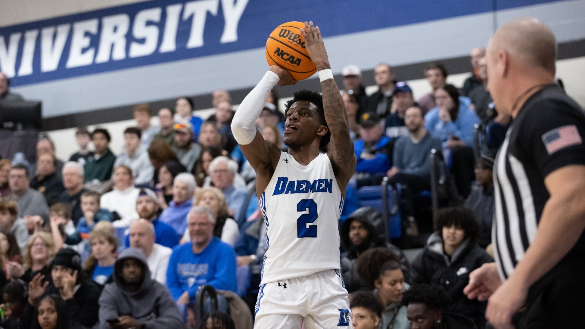 Ryan Heath shoots a three-pointer from the right corner as a sold out crowd looks on
