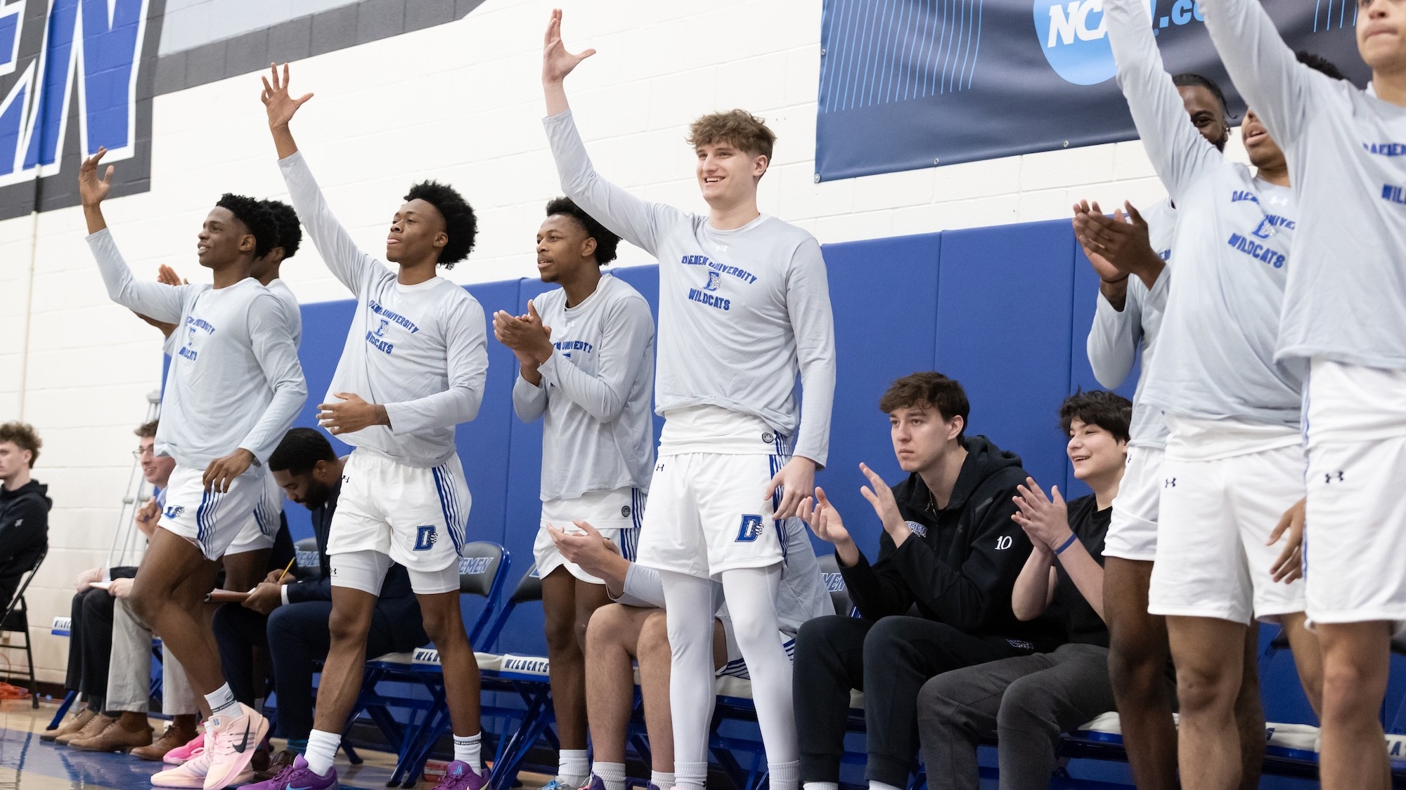 Men's basketball bench cheers during game