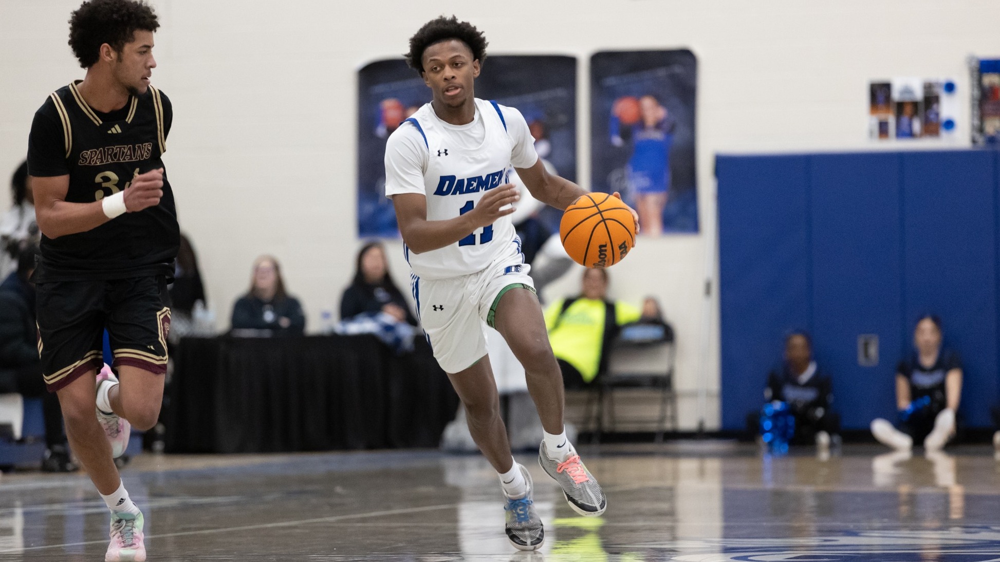 Jaymeir Goosby dribbles up the court as a defender from St. Thomas Aquinas runs along his right side