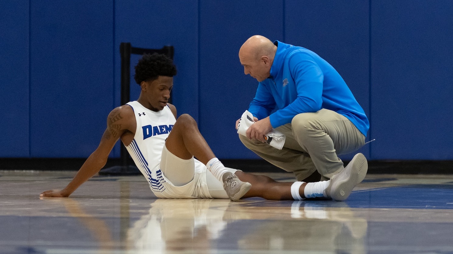 Jeff Sage kneeling down with an injured athlete