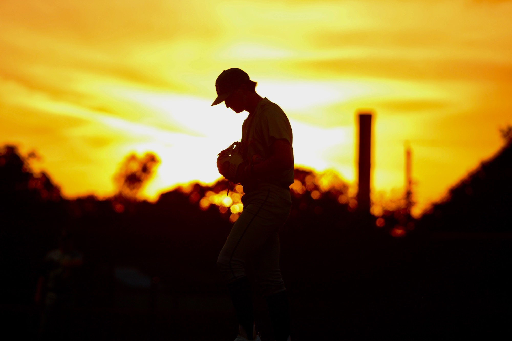 Giancarlo Arencibia pitching with sunset background 