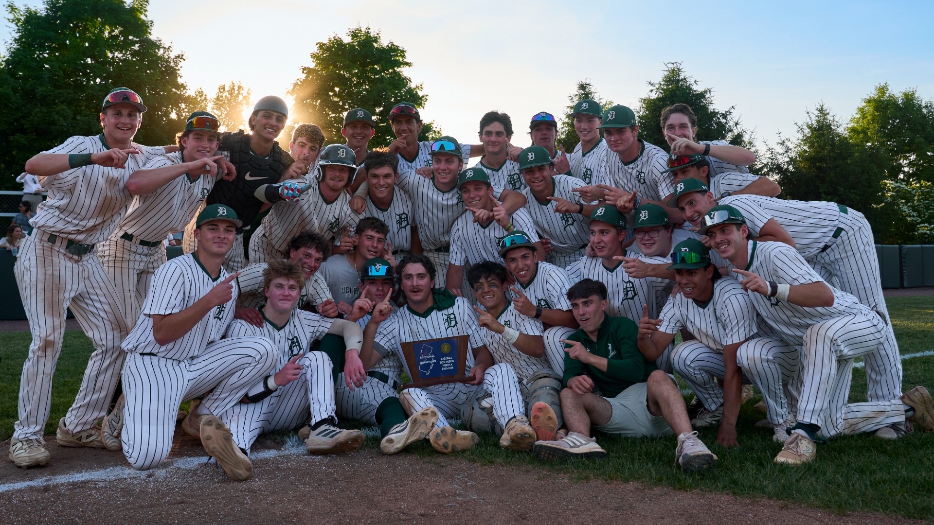 baseball team poses with team trophy