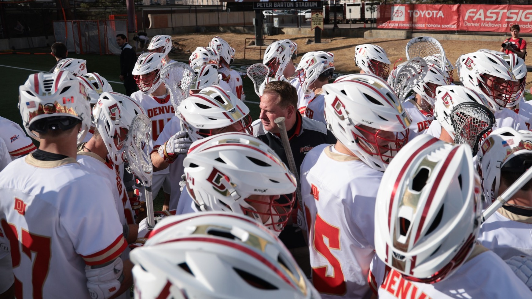 Matt Brown leads the huddle of the Denver men's lacrosse team after its win over Michigan