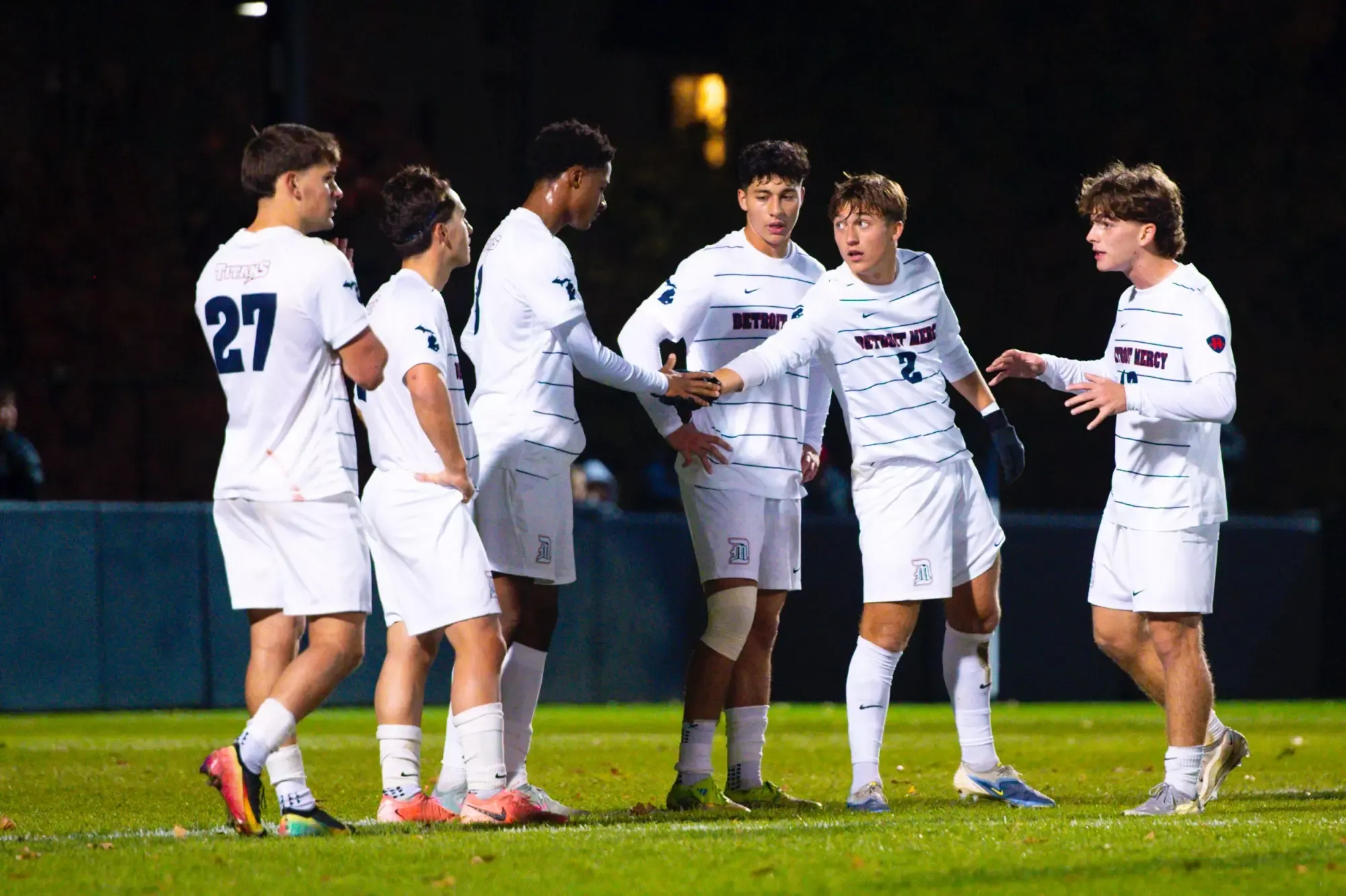 Vincent Stockton, senior midfielder/defense (2), high-fives Tom Nkassa, freshman defense.