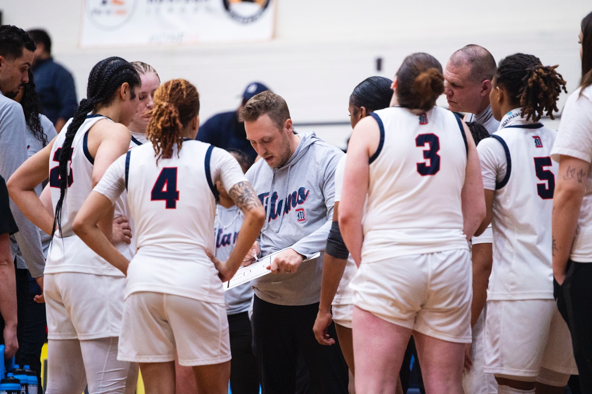 Kiefer Haffey, head women's basketball coach, addresses the team during a timeout.