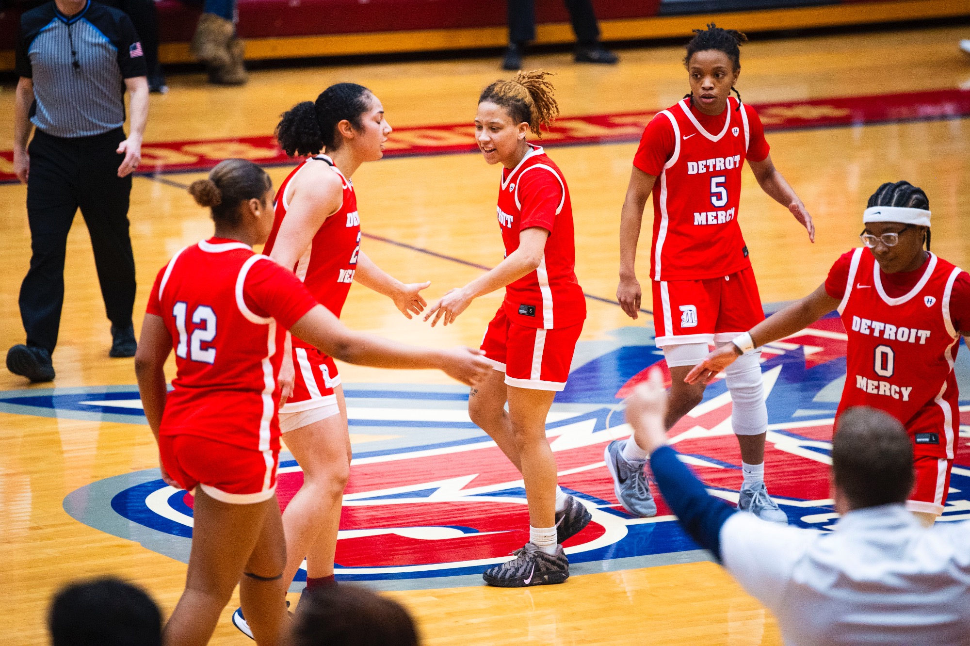 Myonna Hooper, senior guard (center), celebrates with teammates after a basket.