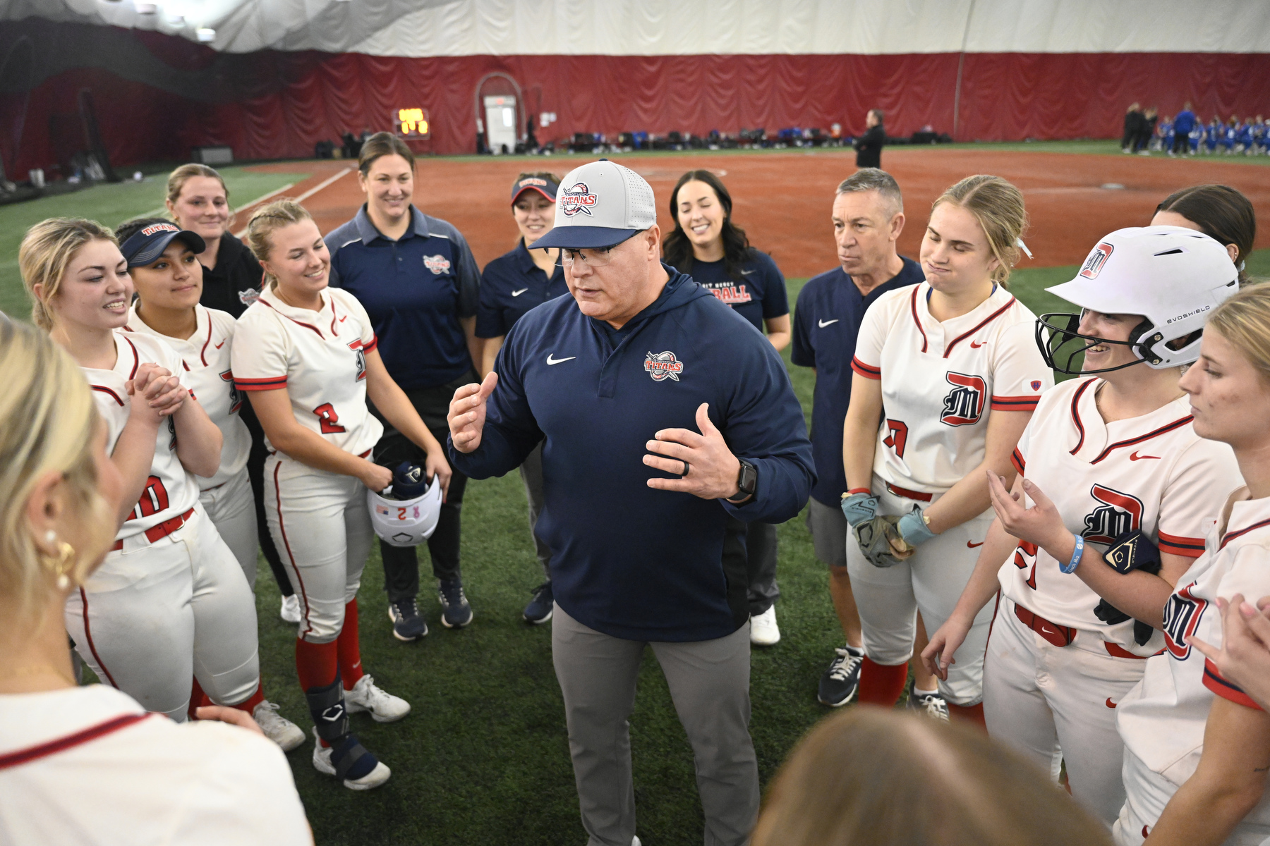 Detroit Mercy softball head coach Dan Vitale, center, talks to his team after their 2-1 win over Drake University, Friday, February 6, 2025, at The Dome at the Parkway Bank Sports Complex in Rosemont, IL.