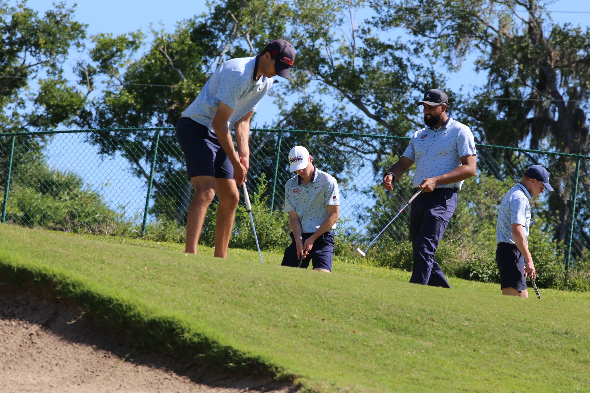 Men's golf team warming up on the course 