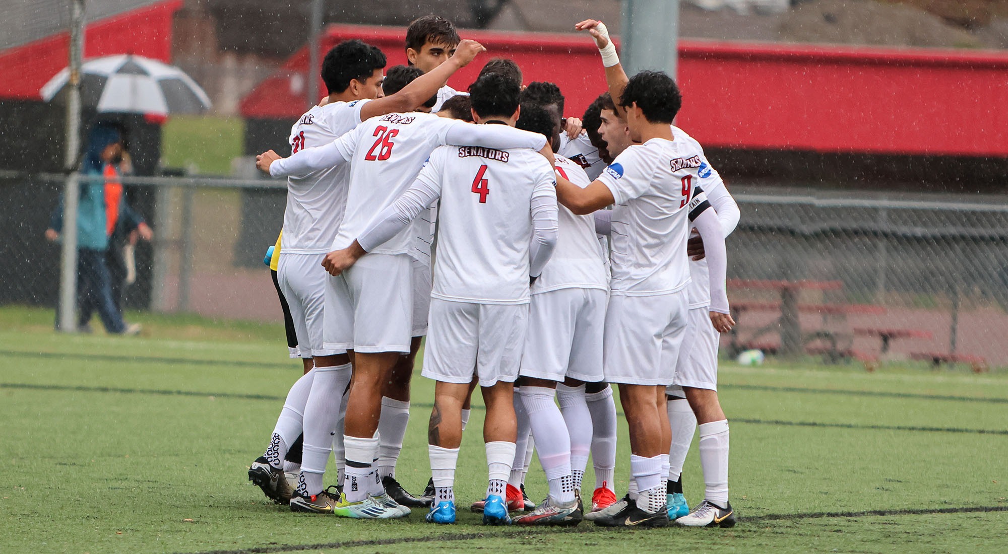 Senators men's soccer team huddles before a game
