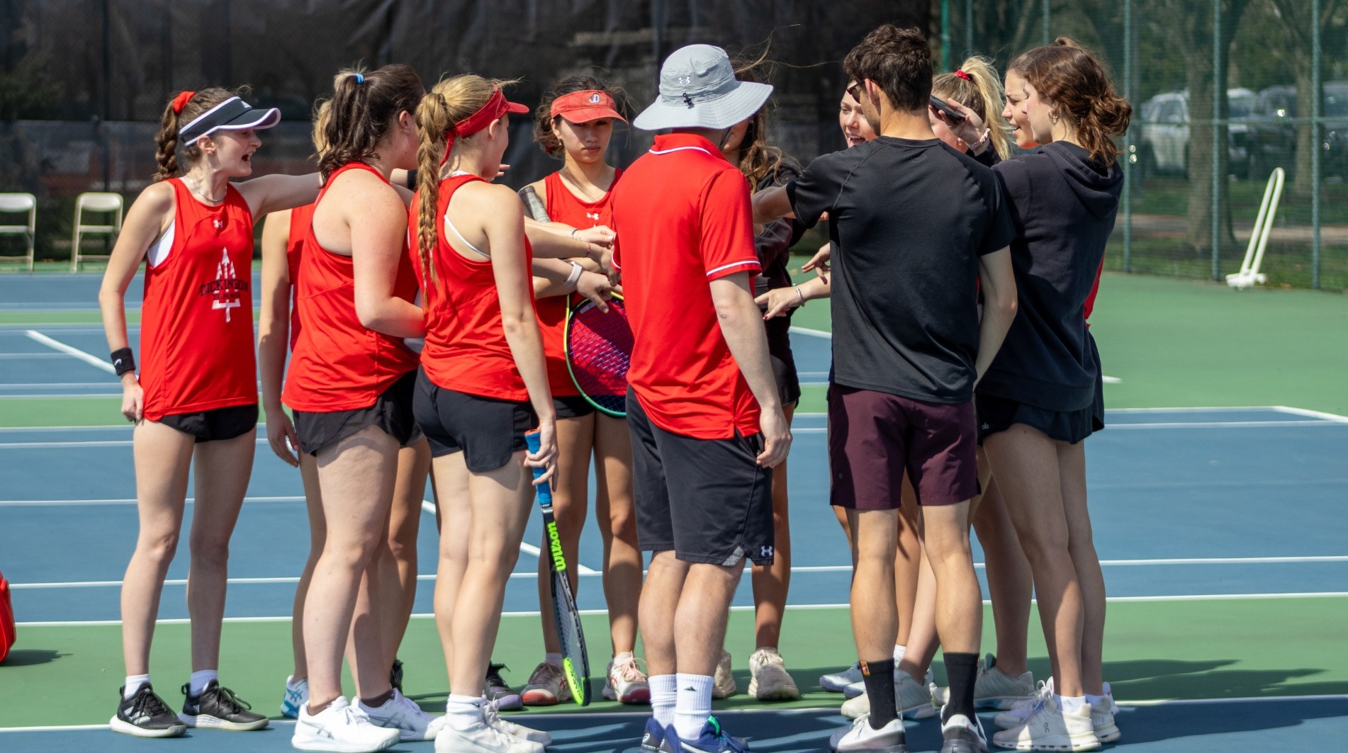 Women's tennis team huddle after match against Bryn Mawr College during the 2025 spring season
