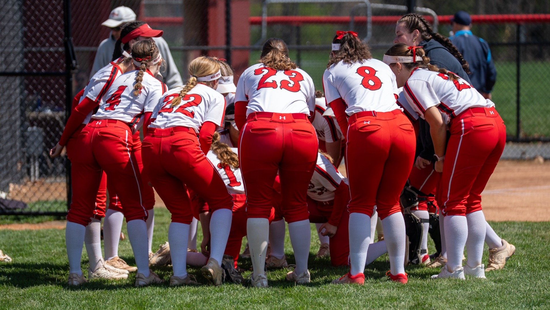 Softball team huddle before senior day festivities against Ursinus College