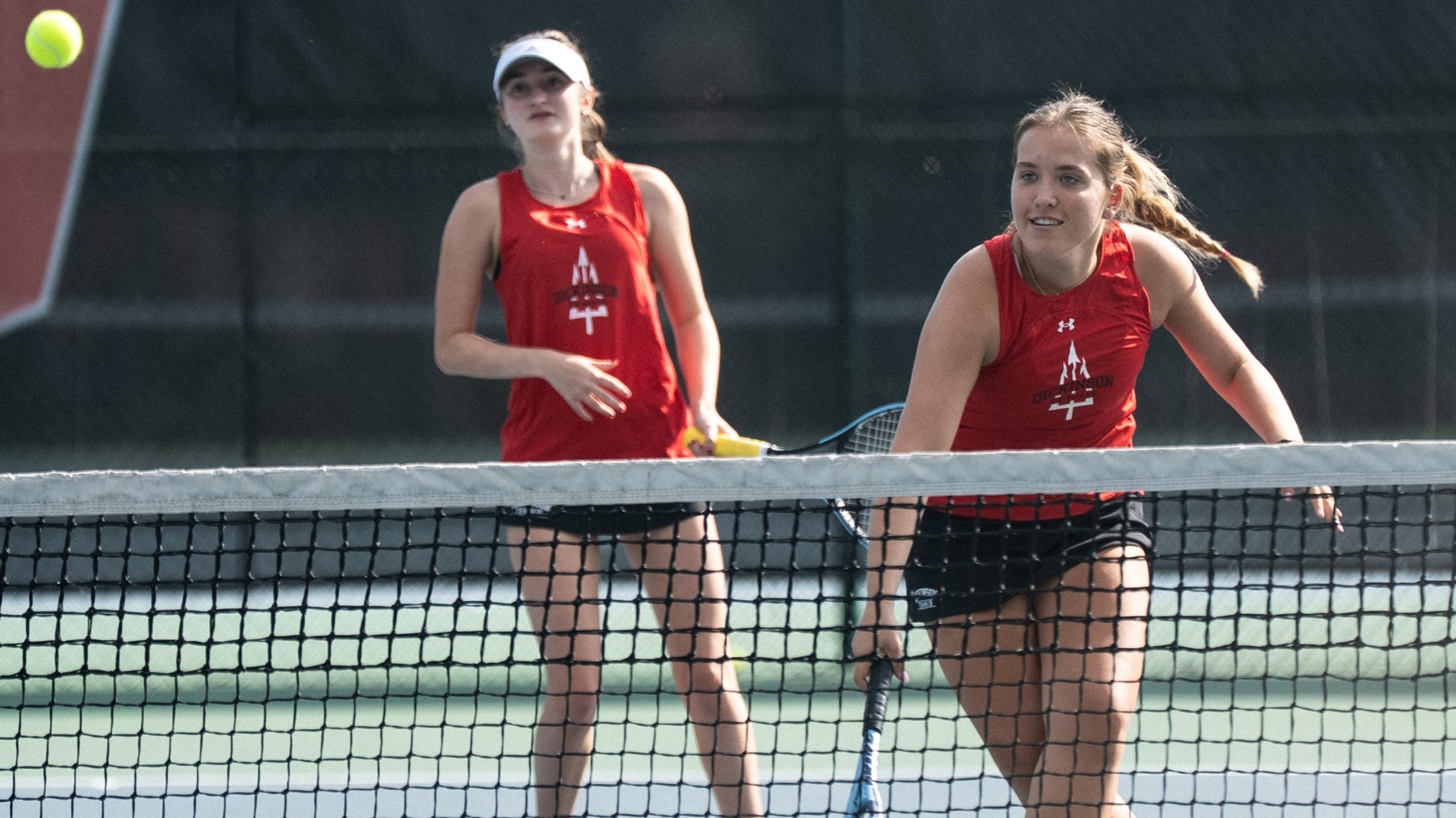 Women's doubles team playing a point against Catholic University during the 2025 fall season