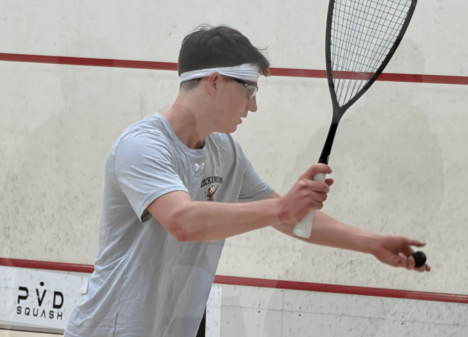 Men's squash player taking a swing against Brown University on 1-12-26