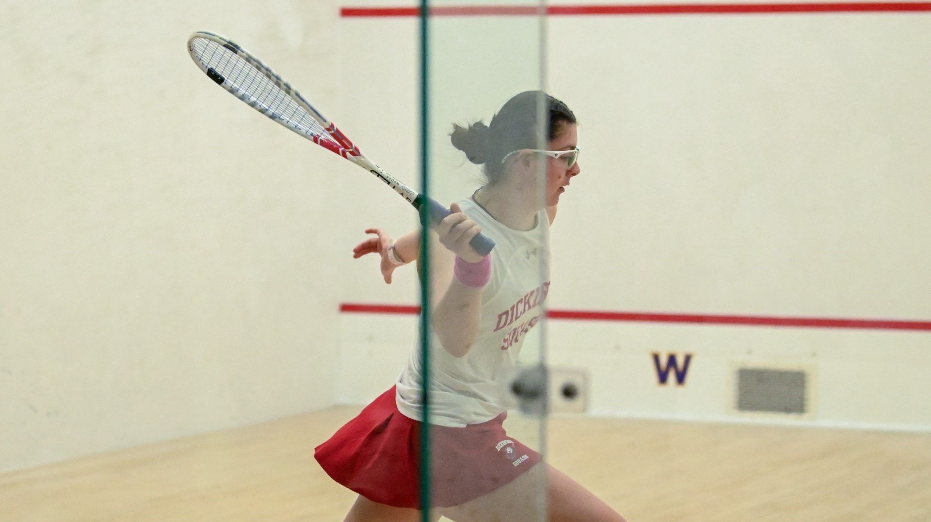 Women's squash player going for a forehand shot at Williams College during the 2026 New England trip.