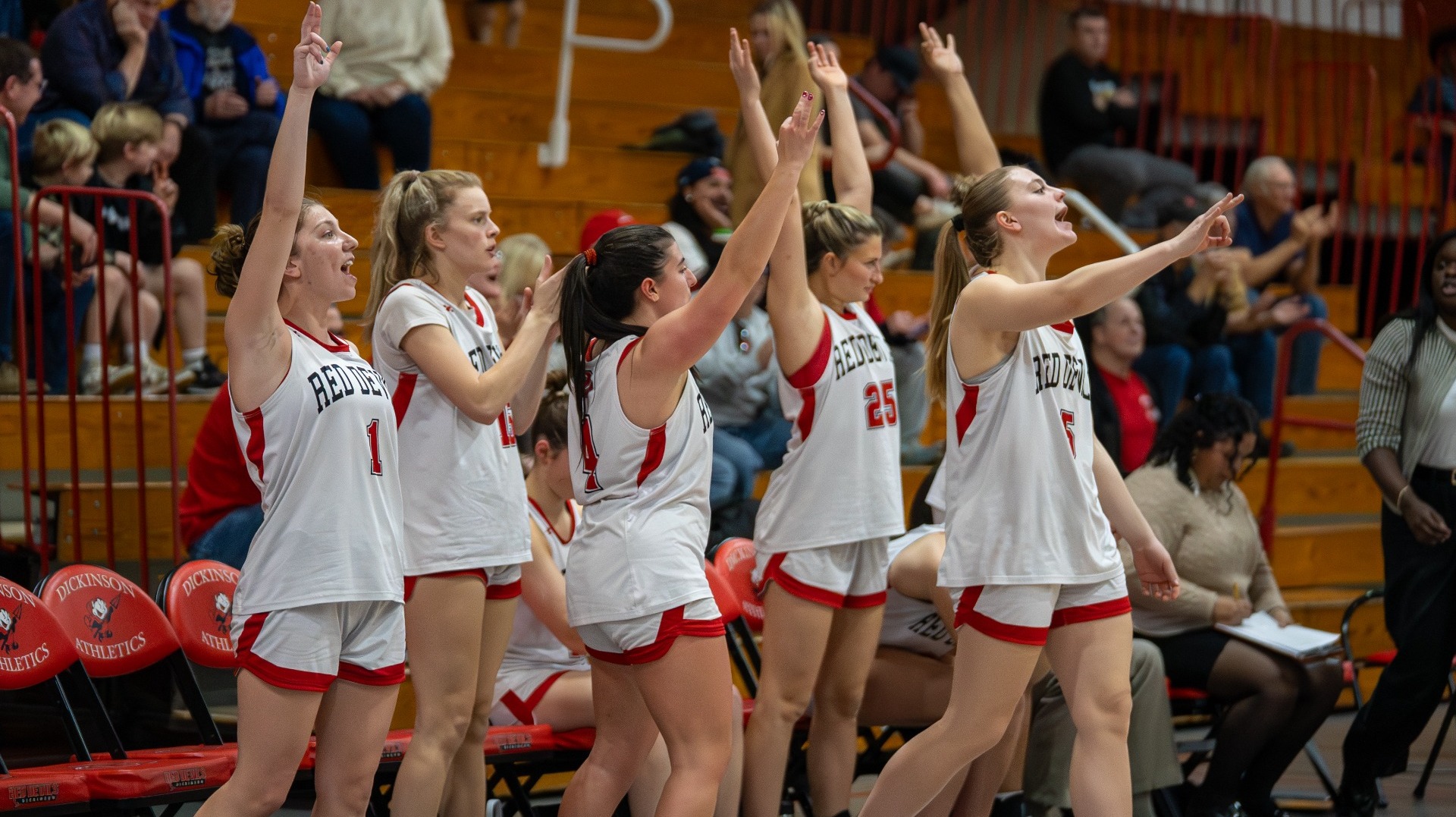 Women's basketball bench celebrating a three pointer against Bryn Mawr College on 1-7-26