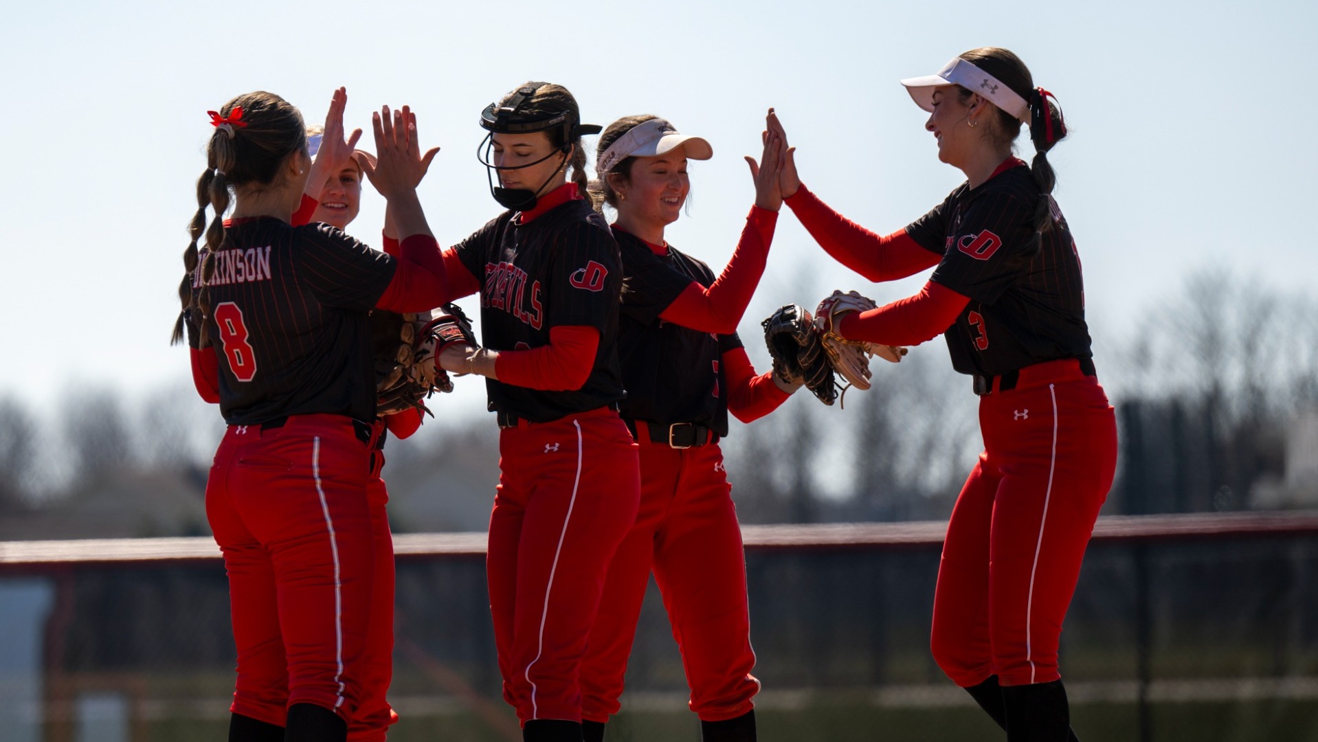 Softball team group high five on the field