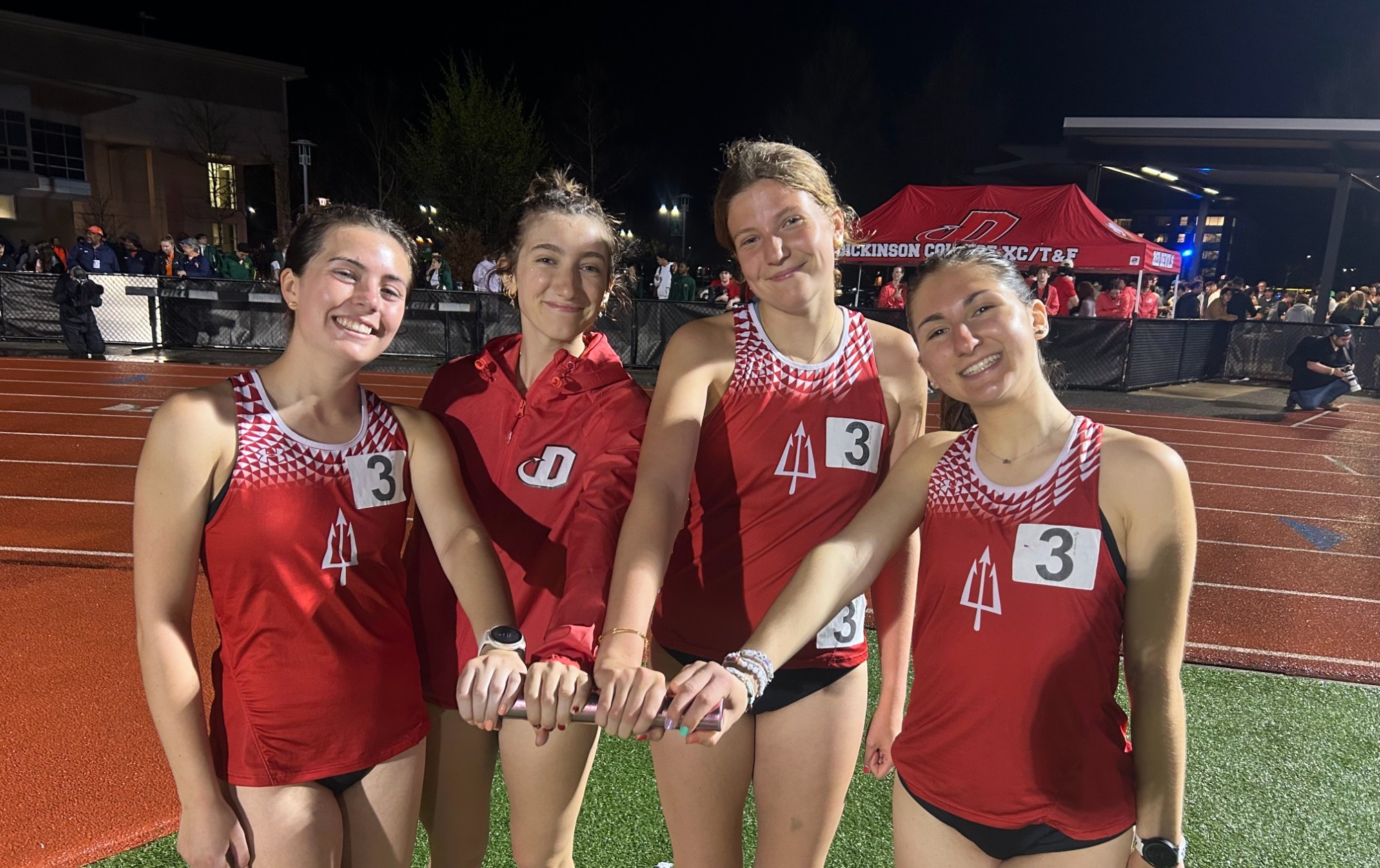 Meghan Higgins-Haas, Liza Barbash, Roma Diak, and Meghan McGinnis pose with a baton 