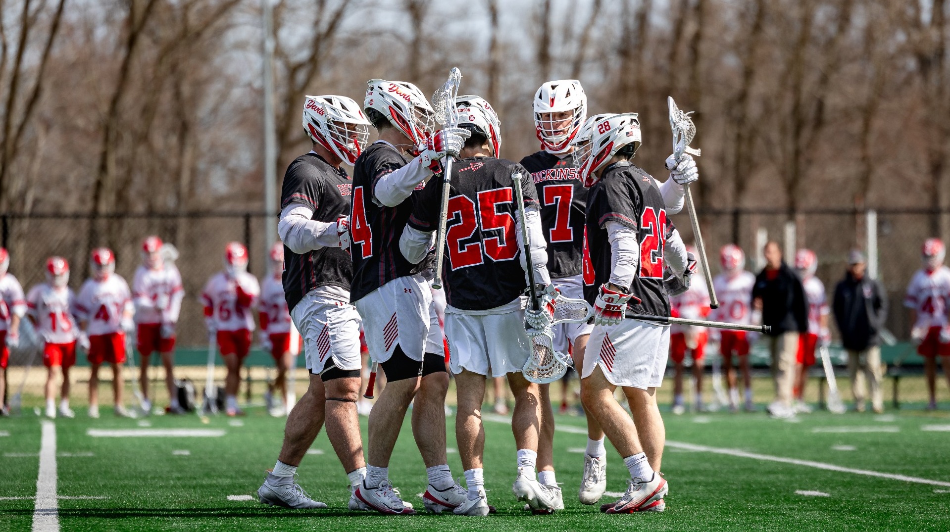 Dickinson men's lacrosse team hug after a goal against Dension University on 3-14-26