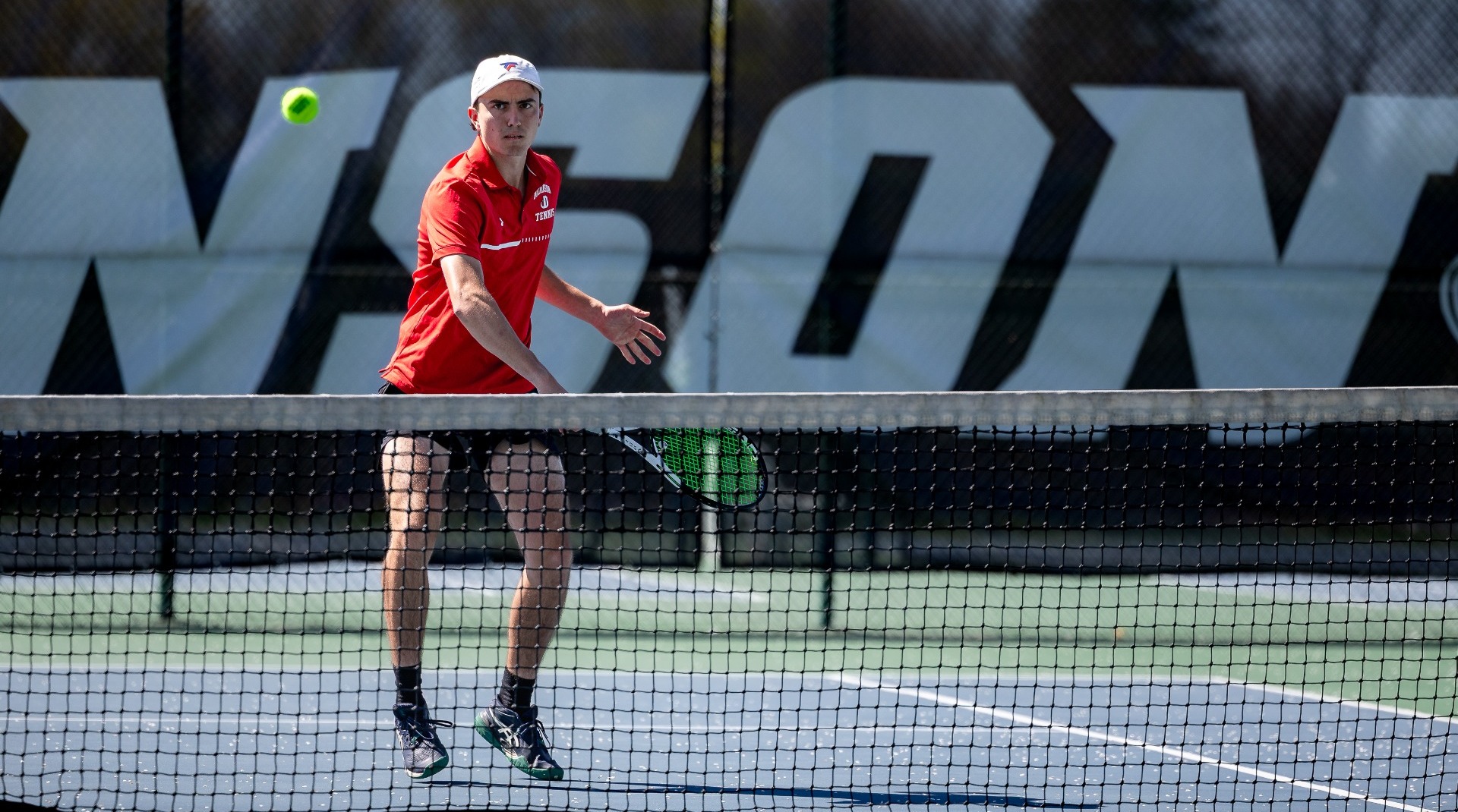 Men's tennis player going for a net front shot against McDaniel College on 4-11-26