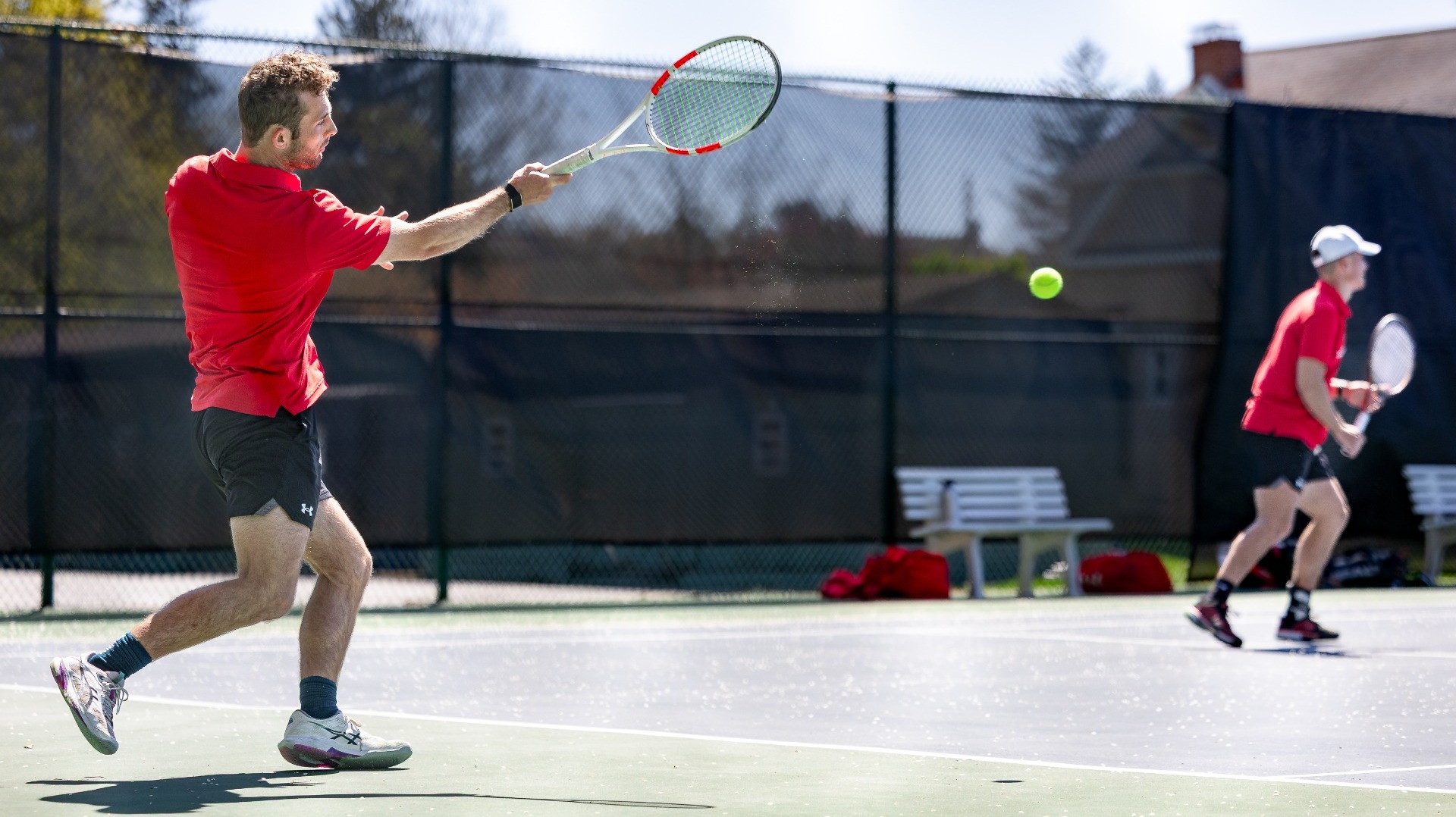 Men's tennis player going for a forehand against McDaniel College during the 2026 spring season