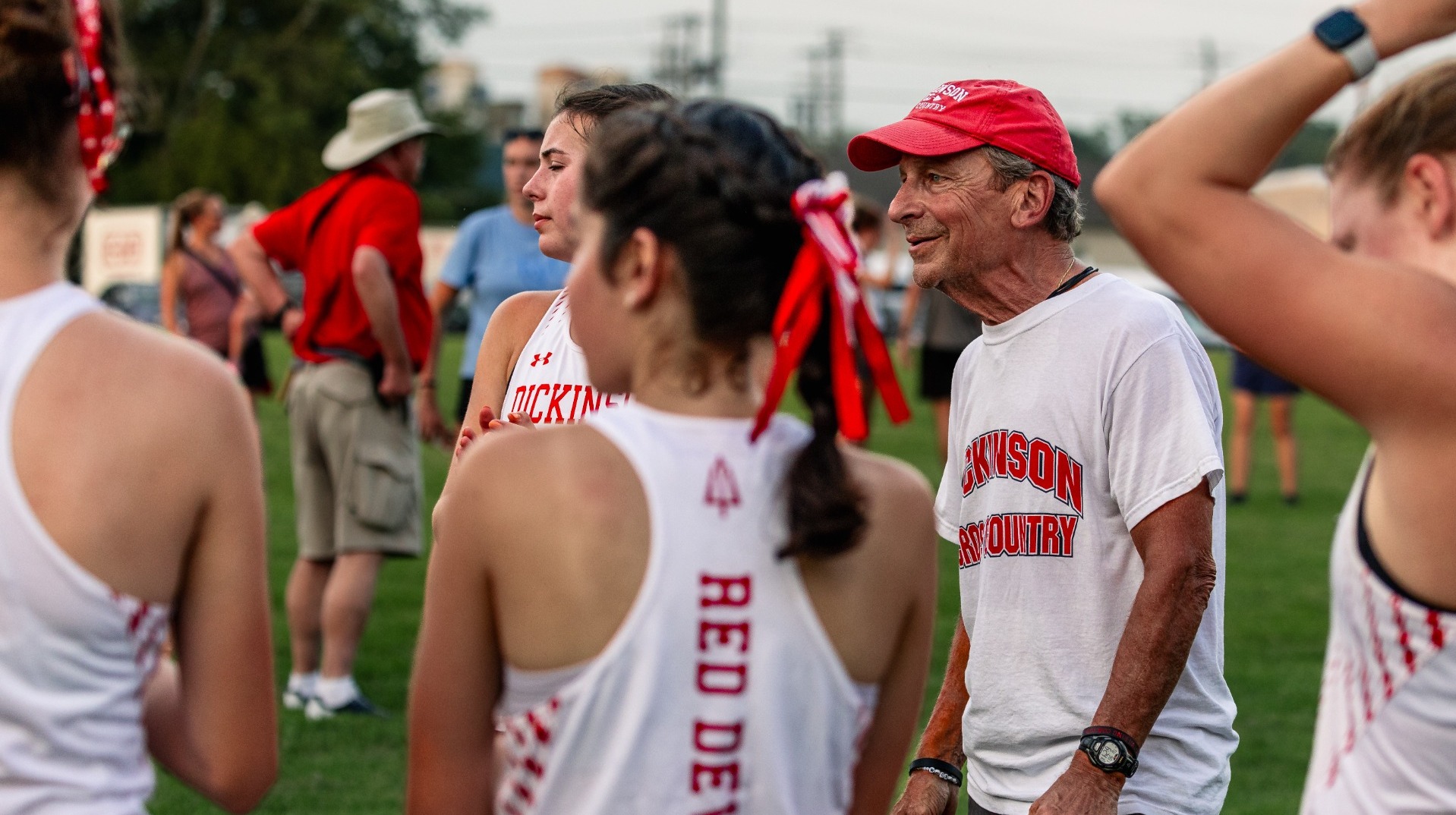Coach Nichter standing with the women's cross country team prior to the Little Three Championship on 9-1-26
