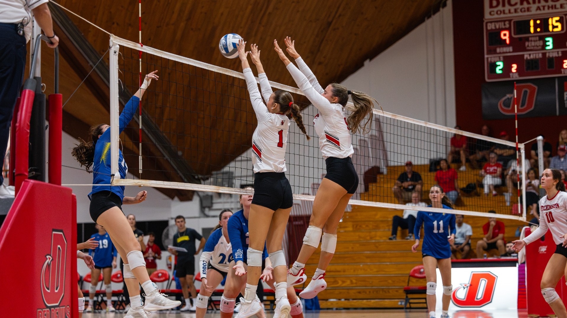Norah Oppenheim and Caroline Cusson going up for a block against Misericordia University on 9-12-26