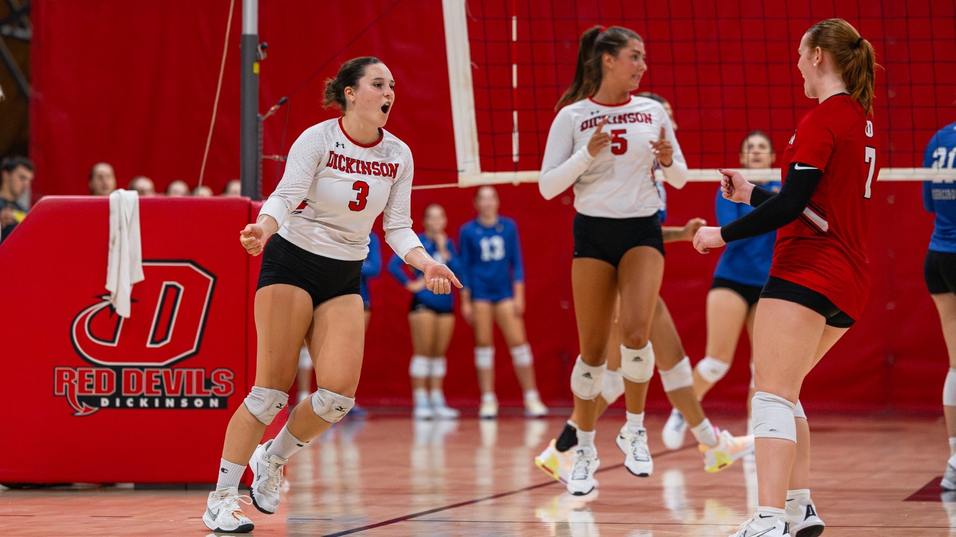 Katie Arcara, Avery Butcher and Mallie Thomas celebrating a point against Misericordia University on 9-12-26
