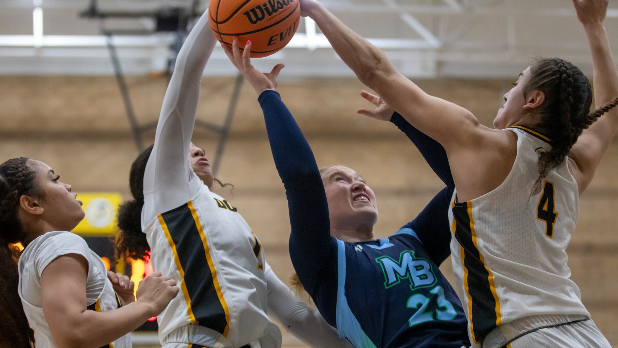 Julianne Cotterill and Keyonee Neal each get a hand on a shot attempt by CSUMB