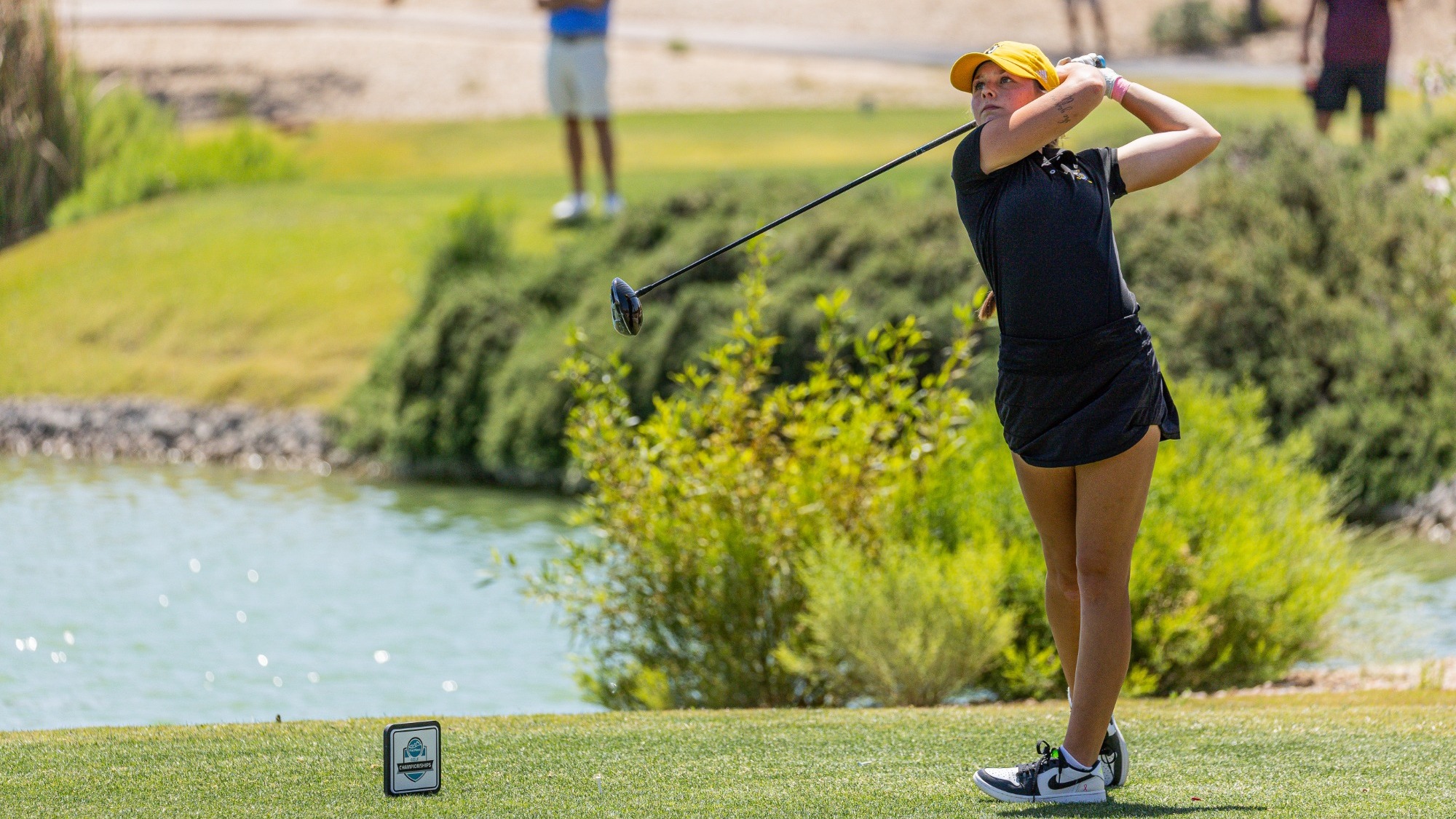Madi Whitney watches a shot off the tee at the PacWest Championships
